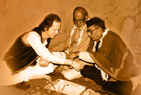 Ustad Mushtaq Ali Khan ties the traditional thread (gandha) which binds the relationship between master and student. The renowned D.T. Joshi, disciple of Enayet Khan, looks on